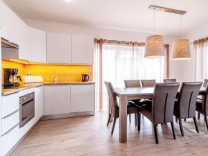 a kitchen and dining room with a table and chairs at Holiday Home Lakeside Village 18 - - sauna by Interhome in Frymburk