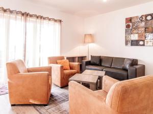 a living room with leather furniture and a couch at Holiday Home Lakeside Village 18 - - sauna by Interhome in Frymburk