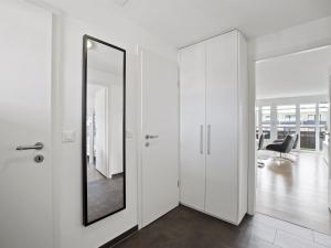 einen weißen Flur mit einem Spiegel und einem Stuhl in der Unterkunft Apartment Nr-78 Haus Ladina by Interhome in Lenzerheide