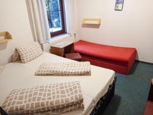 Habitación con 2 camas y banco rojo. en Apartment 637-2 by Interhome en Harrachov