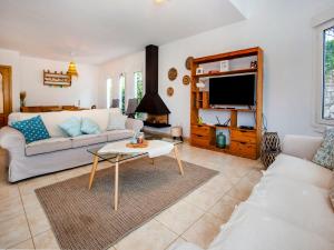 ein Wohnzimmer mit einem Sofa und einem TV in der Unterkunft Holiday Home El Descanso by Interhome in Gata de Gorgos