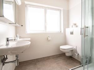 a bathroom with a sink and a toilet and a window at Holiday Home Lakeside Village 35 by Interhome in Frymburk