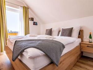 a bedroom with a large bed with white sheets and a window at Holiday Home Lakeside Village 35 by Interhome in Frymburk