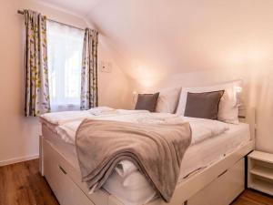a bedroom with a large white bed with a window at Holiday Home Lakeside Village 35 by Interhome in Frymburk