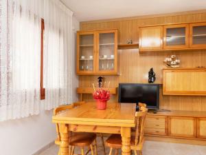 a dining room with a wooden table and a television at Villa Villa Tello by Interhome in L'Ametlla de Mar
