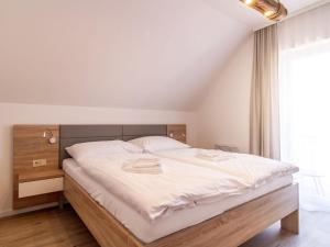 a bedroom with a large bed with white sheets at Holiday Home Lakeside Village 22 - - sauna by Interhome in Frymburk