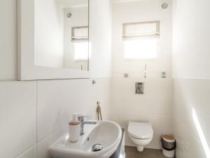a white bathroom with a sink and a toilet at Holiday Home Lakeside Village 22 - - sauna by Interhome in Frymburk
