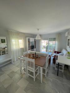 cocina y sala de estar con mesa y sillas en Apartamento Carihuela a 300 metros playa, en Torremolinos