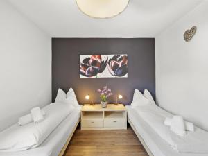 a room with two beds and a table with flowers at Apartment A301 by Interhome in Lenzerheide