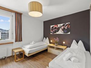 Cette chambre comprend 2 lits et une fenêtre. dans l'établissement Apartment A301 by Interhome, à Lenzerheide