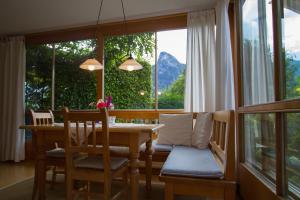 comedor con mesa y sillas y ventana grande en Ferienwohnung Martina Bauer, en Oberammergau