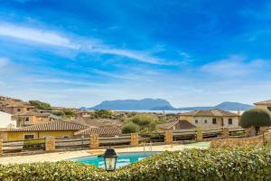 a villa with a swimming pool and mountains in the background at Casa Vacanze Lo Squalo in Olbia