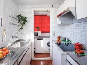 een witte keuken met een wastafel en een rode deur bij Apartment Ondina Plus by Interhome in Playa de Gandia