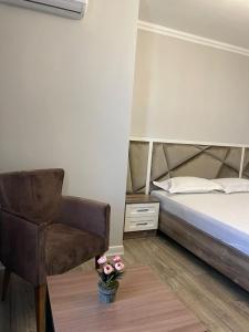 a bedroom with a bed and a chair and a table at Family apartment 7 in Shymkent