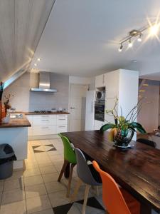 cocina con mesa de madera y sillas verdes en Nimary Logies, en Heusden - Zolder