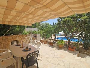 een patio met een tafel en stoelen onder een parasol bij Villa Mercedes by Interhome in Casas de Torrat