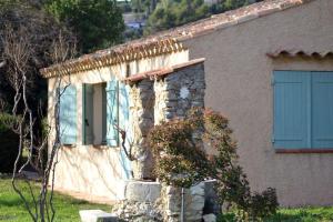 ein kleines Haus mit einer blauen Tür an der Seite in der Unterkunft Lou Jas, maison de charme, à 1 km de la mer in Cassis