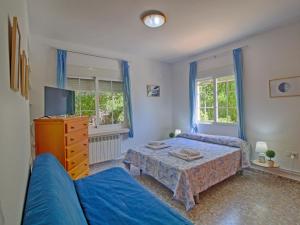 een slaapkamer met een bed, een bank en een tv bij Villa Mercedes by Interhome in Casas de Torrat