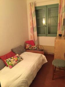 ein kleines Schlafzimmer mit einem Bett und einem Stuhl in der Unterkunft Lou Jas, maison de charme, à 1 km de la mer in Cassis