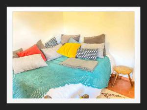Bett mit bunten Kissen auf einem Zimmer in der Unterkunft Lou Jas, maison de charme, à 1 km de la mer in Cassis