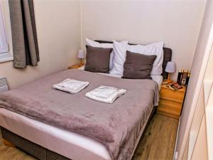 a bedroom with a bed with two towels on it at Holiday Home Lakeside Village 23 - - sauna by Interhome in Frymburk