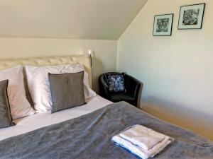 um quarto com uma cama e uma cadeira preta em Holiday Home Lakeside Village 23 - - sauna by Interhome em Frymburk
