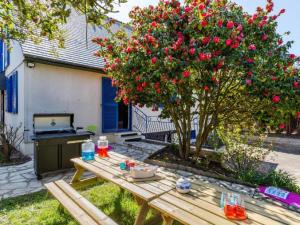 einem Picknicktisch vor einem Baum mit roten Blumen in der Unterkunft Holiday Home La Perle by Interhome in Cancale