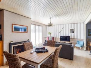 salon ze stołem i kominkiem w obiekcie Holiday Home La Perle by Interhome w mieście Cancale