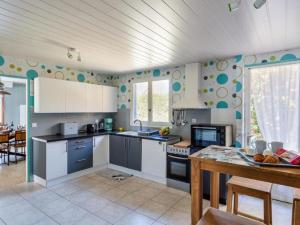 kuchnia z białymi szafkami i stołem w obiekcie Holiday Home La Perle by Interhome w mieście Cancale