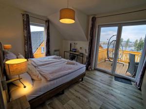 a bedroom with a bed and a balcony at Holiday Home Lakeside Village 36 - - sauna by Interhome in Frymburk