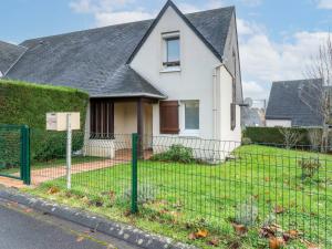 une maison blanche avec une clôture devant elle dans l'établissement Holiday Home Le Vert Coteau-4 by Interhome, à Touques