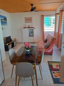 a living room with a table and a couch at LE COLIBRI in Petit-Bourg