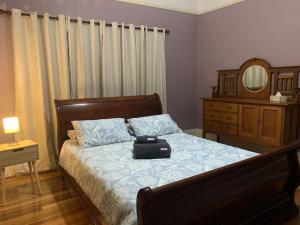 a bedroom with a bed with a suitcase on it at Botanic Bliss Bungalow in Adelaide +21 photos