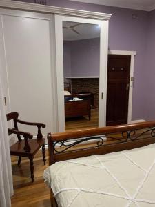 a bedroom with a bed and a large mirror at Botanic Bliss Bungalow in Adelaide