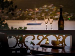 Port Elizabeth的住宿－Gingerbread Suites，一张桌子,上面放着两杯酒和一瓶葡萄酒