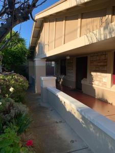 a building with a sidewalk next to a house at Botanic Bliss Bungalow in Adelaide