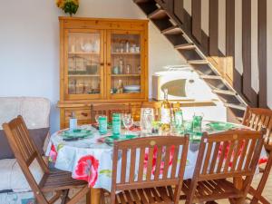 a dining room table with chairs and a wooden cabinet at Holiday Home Les Captivantes II-8 by Interhome in Cap d'Agde