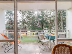a screened in porch with a table and chairs at Apartment Port An Dro-10 by Interhome in Carnac
