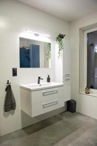 een witte badkamer met een wastafel en een spiegel bij Chalupy Slunná in Jeseník