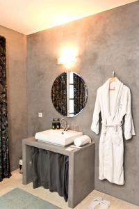 een badkamer met een wastafel en een badjas aan een muur bij VILLA BELLUCIA in Cateri