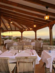 een restaurant met witte tafels, stoelen en verlichting bij VILLA BELLUCIA in Cateri