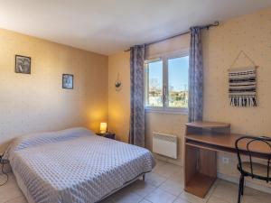 1 dormitorio con cama, escritorio y ventana en Holiday Home Maison Cléo by Interhome en Cogolin