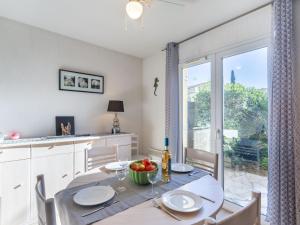 una cucina e una sala da pranzo con tavolo, sedie e finestra di Holiday Home Maison Cléo by Interhome a Cogolin Altre 16 foto