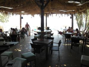 a restaurant with people sitting at tables and chairs at Megim Hotel in Palaiochora
