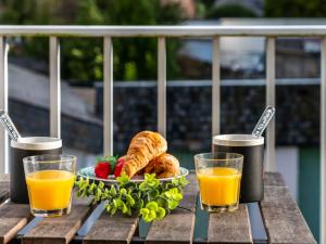 a table with a plate of food and two glasses of orange juice at Apartment Les Embruns-5 by Interhome in Carnac