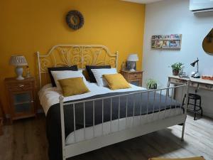 a bedroom with a large bed with yellow walls at De Drechtstee in Dordrecht