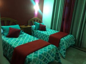 2 camas en una habitación con verde y rojo en Villa Calma, en Yaiza