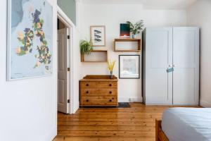 um quarto com uma cama e uma cómoda em madeira em Treetops - Characterful flat with parking, close to beach em Falmouth
