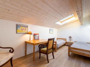 Pokój z biurkiem i łóżkiem oraz łóżkiem i łóżkiem w obiekcie Holiday Home Hibiscus by Interhome w mieście Lacanau