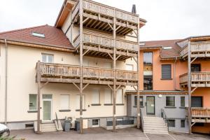 un edificio con balcones de madera en un lateral en Ouréa - duplex avec balcon, en La Bresse